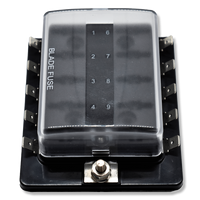 Top view of fuse block with clear hinged cover, numbered slots, mounting stud and side blade terminals