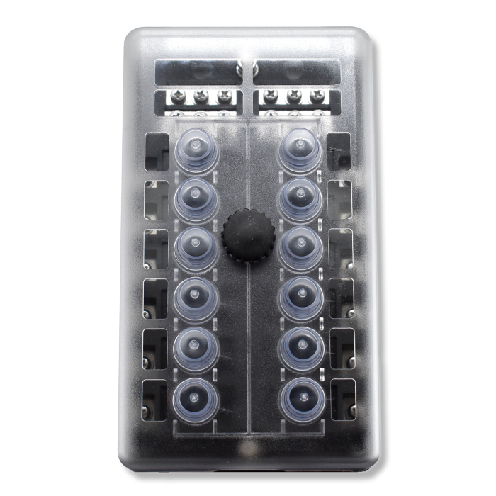 Front view of breaker block with translucent cover revealing 12 rubber boots, central knob and top terminals.
