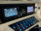Grady-White Bimini 306 dash panel, angled view of dual Garmin displays and illuminated labeled switch panel