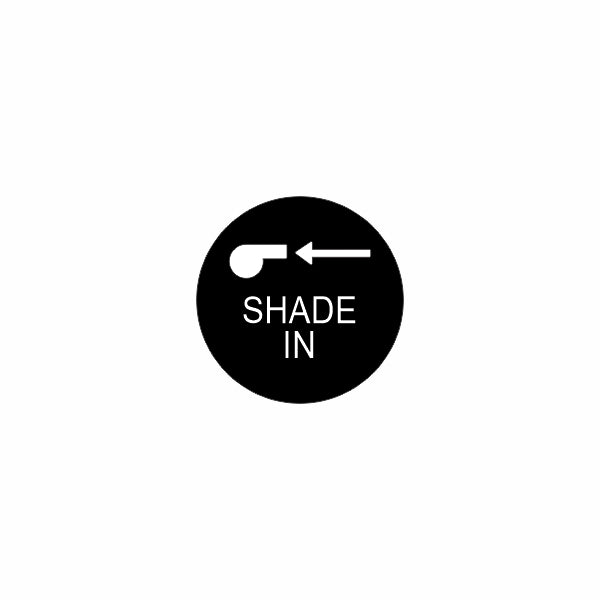 Close-up of actuator control face showing black circular label with white knob icon, left arrow and "SHADE IN".