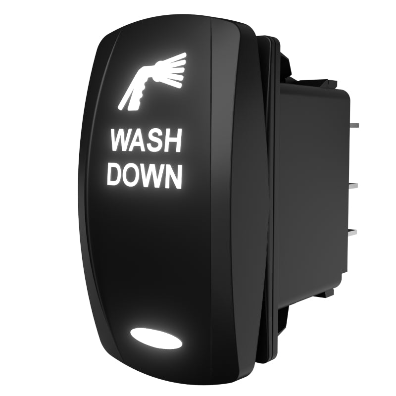 Angled side/rear view of WASH DOWN switch showing illuminated rocker, rear connector pins and mounting depth.