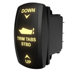 Angled rear view of a starboard trim tabs rocker switch with illuminated labels and visible connector pins