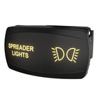 Angled view of Carling spreader lights rocker switch showing illuminated legend and side snap-in mounting housing