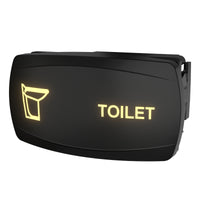 Angled view of illuminated toilet indicator switch panel with yellow toilet icon, 'TOILET' text and rear mounting clip.