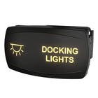 Angled front-right view of illuminated Docking Lights switch showing backlit label and rear mounting clip