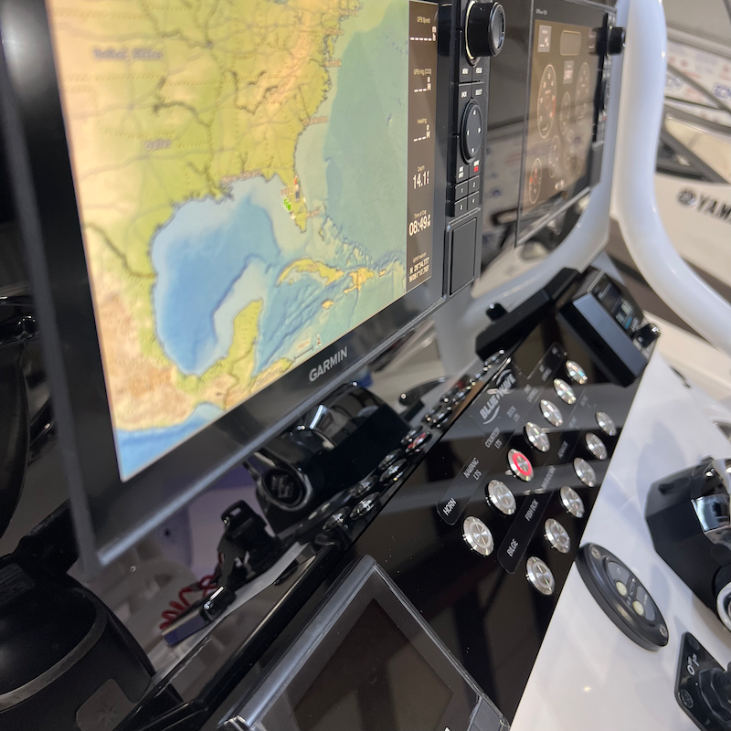 Blue Wave 2800 Makaira dash panel, angled view with Garmin screens and stainless push-button switches.