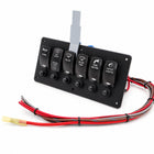 A black marine toggle switch panel with six labeled switches including horn, windshield wiper, blade blade, raw water, and catsey lights, with attached wiring and a gray mounting bracket on a white background.