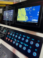 Angled close-up of Dusky 31 CC dash panel showing two Garmin displays and blue-backlit switches