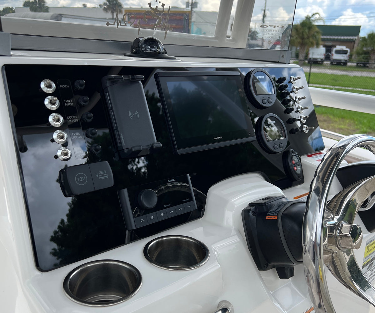 Robalo R222 dash angled view showing Garmin screen, Yamaha gauges, multiple toggle switches and compass