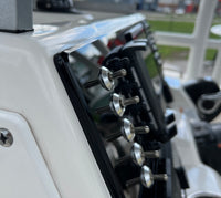 Angled close-up of Robalo R222 dash panel showing stainless toggle knobs, chrome bezels and mounting edge