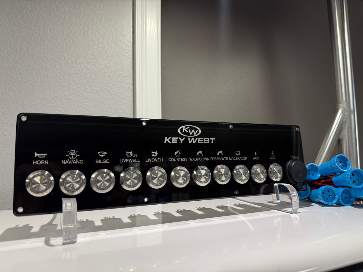 Front view of Key West switch panel showing labeled control icons, metal round switches and blue connectors.