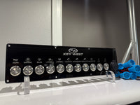 Front view of Key West switch panel showing labeled control icons, metal round switches and blue connectors.
