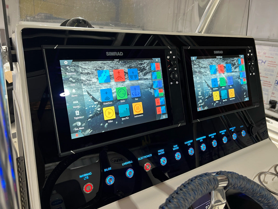 Front view of the Key West 263 FS dash panel showing dual Simrad displays and labeled illuminated switches.